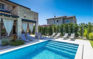 a swimming pool with chairs and a house at Villa Calma in Šivati +52 photos