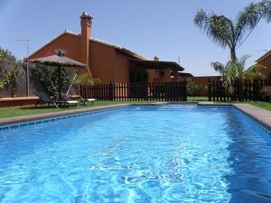 a large blue swimming pool in front of a house at Villa Marta Clara in Conil de la Frontera