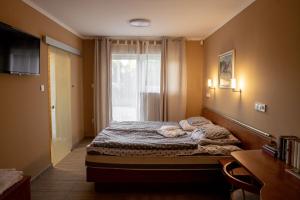 a small bedroom with a bed and a window at Borház in Dédestapolcsány