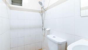 a white bathroom with a shower and a toilet at RedDoorz at DBuilders Rooms Ph2 Taguig in Manila