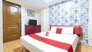 a bedroom with a large bed with a red and white blanket at RedDoorz at DBuilders Rooms Ph2 Taguig in Manila