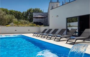 una piscina con sedie e una casa di Villa Subventus a Bajčići