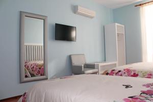 Grande Oceano Guest House في بورتو: غرفة نوم بسرير ومرآة وكرسي