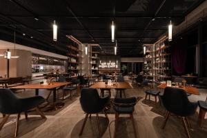 a restaurant with wooden tables and chairs at Wanda Moments Hotel Beijing Dongba in Beijing
