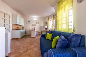 un salon avec un canapé bleu et une cuisine dans l'établissement La Casa Al Mare, à Castelsardo