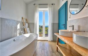 a bathroom with two sinks and a large window at Villa Vela Muline in Zadar