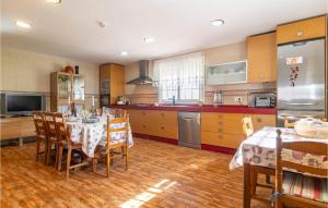a kitchen with a table with chairs and a refrigerator at Lovely Home In Chiclana De La Fronter in Chiclana de la Frontera