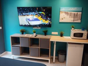 a desk with a microwave and a tv on a wall at Bedroom Agde 34300 in Agde