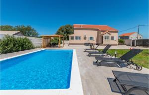 basen z leżakami i dom w obiekcie Cozy Home In Biograd Na Moru w Biogradzie na Moru