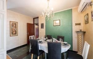 ein Esszimmer mit einem Tisch mit Stühlen und einem Kronleuchter in der Unterkunft 3 Bedroom Stunning Home In Podstrana in Podstrana