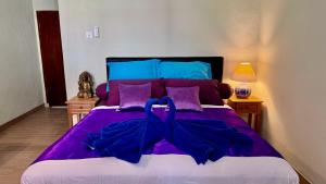 a purple bed with a blue bow on it at Ellenbrook Rooms 17 by Mulia Cottage in Seminyak +16 photos