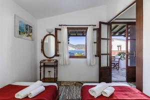 two beds in a room with a view of the ocean at Studios Elpiniki in Skopelos Town