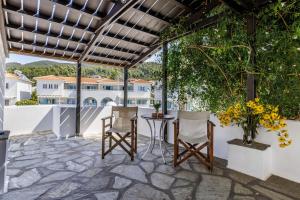a patio with chairs and a table and a building at Studios Elpiniki in Skopelos Town