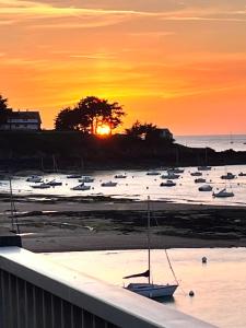 a group of boats in the water at sunset at Appartement Lancieux in Lancieux