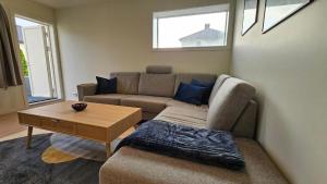 Una sala de estar con un sofá y una mesa de café. en Aalesund Guesthouse 4 Bedroom, en Ålesund