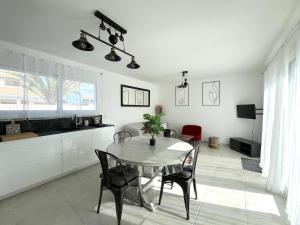 a kitchen and dining room with a table and chairs at Maison Chez les 4 M in Lamarque