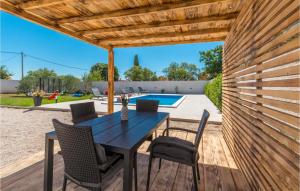 stół i krzesła pod drewnianą pergolą w obiekcie Cozy Home In Biograd Na Moru w Biogradzie na Moru