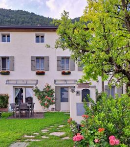a large white house with a table and chairs in the yard at Casa Paola in Borso del Grappa