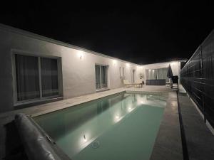 a swimming pool in a house at night at Maison Chez les 4 M in Lamarque