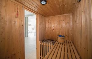 Una habitación de madera con un banco con un reloj en la pared. en Lovely Home In Solin With Sauna, en Solin