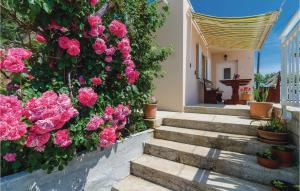 a garden with pink flowers and stairs in front of a house at One-Bedroom Apartment In Gruda in Gruda