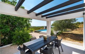 a patio with a table and chairs and a pool at Villa Black Wood in Zadar