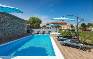 a swimming pool with chairs and umbrellas next to a building at Villa Imela in Pula
