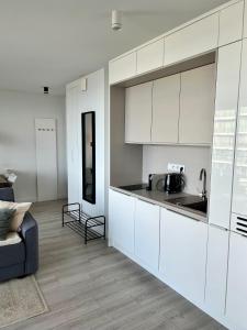 een keuken met witte kasten en een woonkamer bij Wave Sea View Private Apartment - A864 in Międzyzdroje