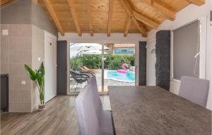 a dining room with a table and chairs and a pool at Lovely Apartment In Polaca With Wifi in Polača
