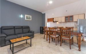 a living room with a couch and a table and chairs at Lovely Apartment In Polaca With Wifi in Polača