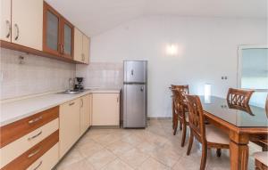 a kitchen with a table and a stainless steel refrigerator at Lovely Apartment In Polaca With Wifi in Polača
