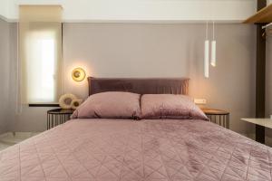a bedroom with a large bed with a pink comforter at Diamond Gold Suite in Iraklitsa