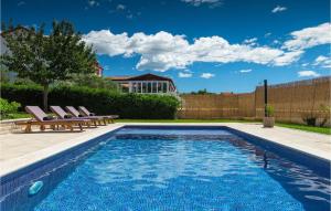 a swimming pool in a backyard with two lounge chairs at Villa Maria Betiga in Pula