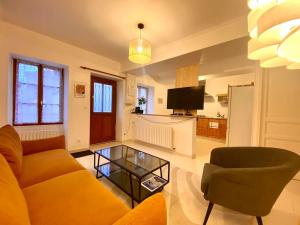 ein Wohnzimmer mit einer Couch und einem Couchtisch in der Unterkunft Maison 2 chambres, village calme - Village Vaux 3 minutes Auxerre in Auxerre