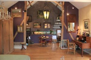 a living room with a table and a dining room at La Passiflore B&B in Bossière