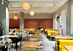 a restaurant with tables and yellow tables and chairs at Rio Inn hotel в районе EXPO in Astana