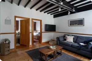 a living room with a couch and a tv at Classy two bed home - close to town centre & beach in Exmouth