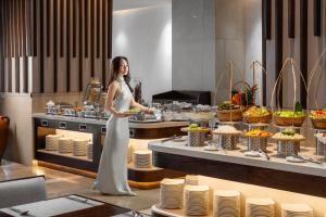 a woman standing in a kitchen with a plate of food at Green Beach Hotel Nha Trang in Nha Trang +130 photos