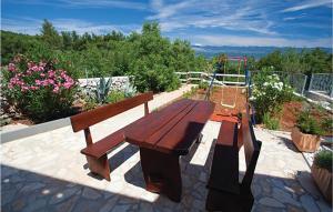 a wooden bench with a swing and a playground at Nice Apartment In Malinska in Malinska