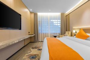 a hotel room with a large bed and a flat screen tv at 天门山云尚景豪酒店 in Zhangjiajie