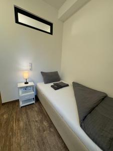 a bedroom with a bed and a lamp on a night stand at BIELEFELD CITY APARTMENTS - komfortable Einzelzimmer und Doppelzimmer - moderne Badezimmer, schnelles WLAN, Self-Check-In in Bielefeld