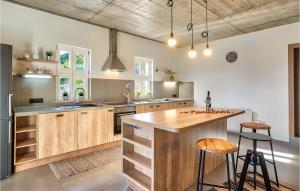 une cuisine avec des armoires en bois et un îlot avec des tabourets de bar dans l'établissement Villa Pia, à Opatija