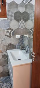 a bathroom with a sink and a tile wall at Casa vacanza da Gabry sardinia in Porto Rotondo +32 photos