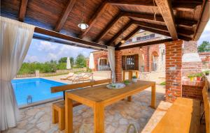 een patio met een houten tafel en een zwembad bij Villa Oxalis in Poreč