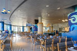 a dining room with tables and chairs in a restaurant at Wonderland Resort Phan Thiet in Phan Thiet