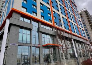 a tall building with a blue and red at Rio Inn hotel в районе EXPO in Astana
