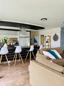 Una sala de estar con un sofá y una cocina. en Izmir Penthouse, en Swakopmund