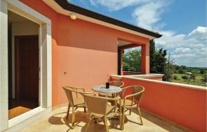 taras ze stołem i krzesłami na balkonie w obiekcie 4 Bedroom Awesome Home In Umag w mieście Murine