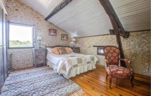 a bedroom with a bed and a chair and a window at 4 Bedroom Lovely Home In Douzillac in Douzillac