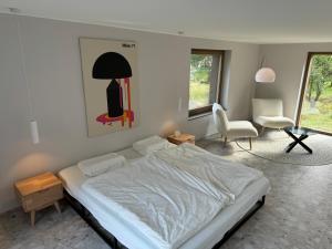 a bedroom with a bed and a table and a chair at Foundation - Waldhaus mit Sauna & Hottub in Zittau +17 photos